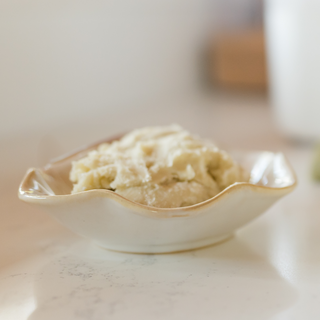 Small dish of shea and cocoa butters on the kitchen countertop while making cold process soaps