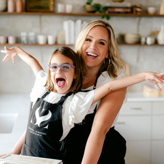 Mother and daughter, founder of Blissed Botanical Co wearing matching aprons and smiling with joy