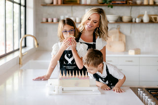 Founder of Blissed Botanical Co and her family wearing matching aprons and cutting cold process soap together