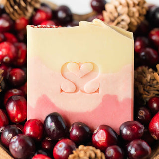Up close bowl of Crackling Cranberry cold process bar soap filled with cranberries and pinecones